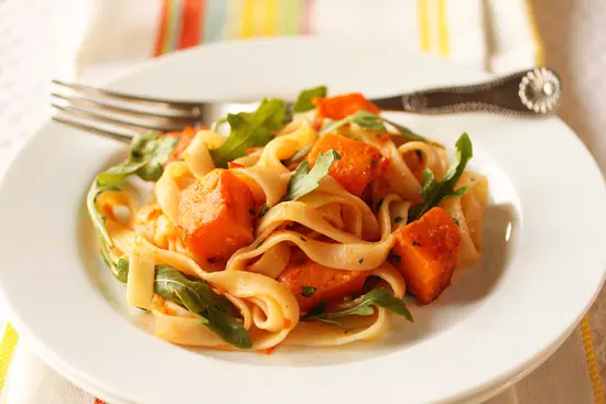 A plate of pasta with some vegetables on it