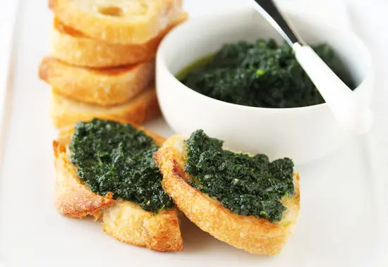 A white plate topped with bread and spinach dip.