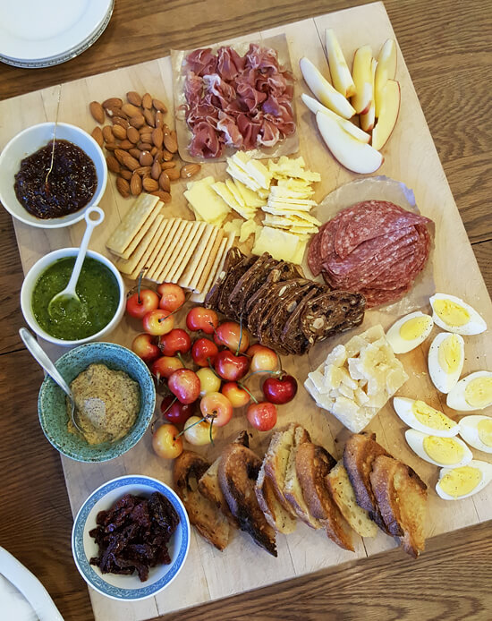 Charcuterie board with meats, cheeses, and fruits.