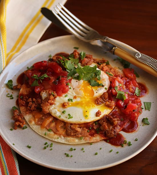 A plate of food with an egg on top.