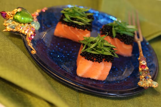 A plate of food with three pieces of salmon.