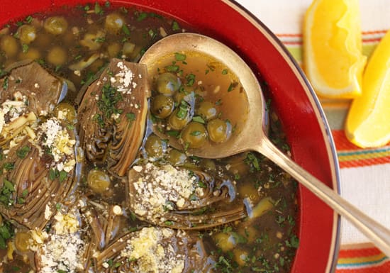 A red bowl of soup with wooden spoons.