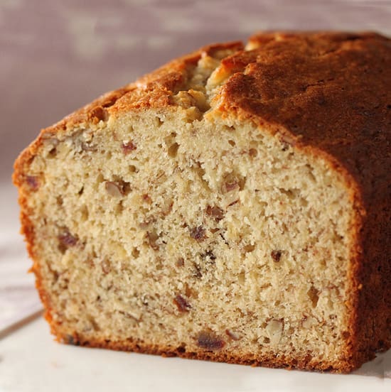 A loaf of banana bread with nuts on top.