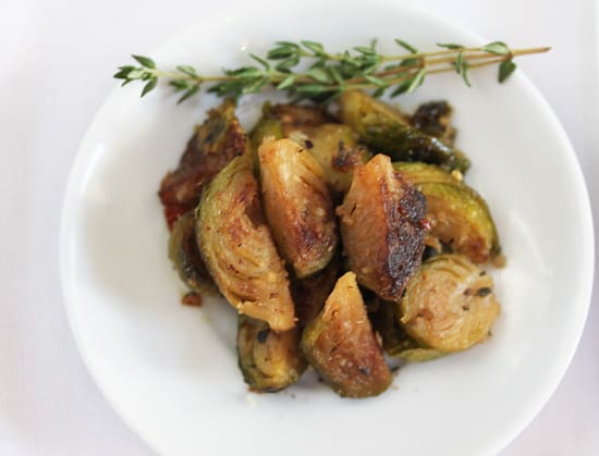 A white plate topped with fried vegetables covered in sauce.