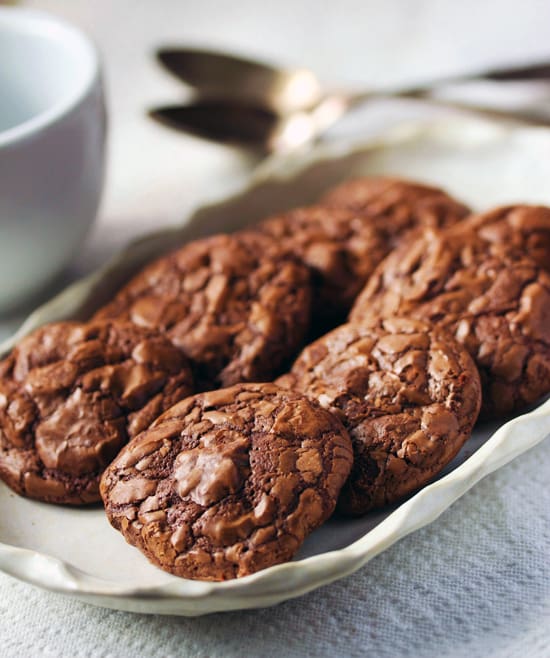 A plate of chocolate cookies on top of the table.