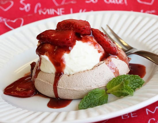 A white plate topped with ice cream and strawberries.