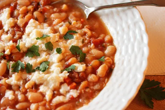 A bowl of beans and cheese on top of a table.