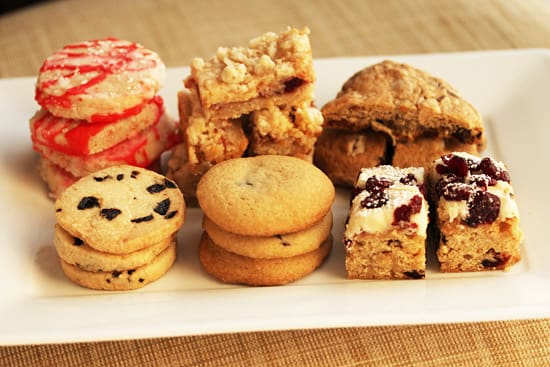 A white plate topped with lots of different cookies.
