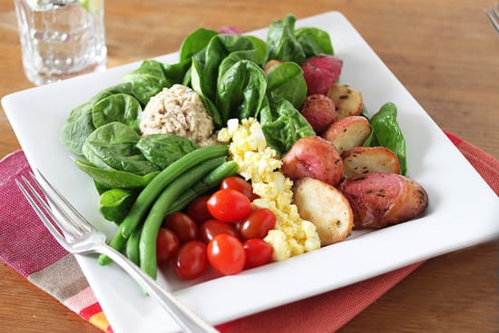 A white bowl filled with vegetables and potatoes.