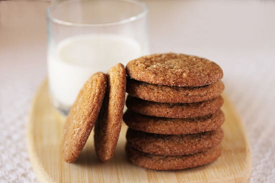 A stack of cookies next to a glass of milk.