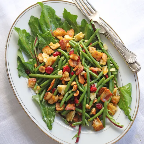 A plate of food with green beans and meat.