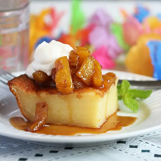 A piece of cake with whipped cream and fruit on top.