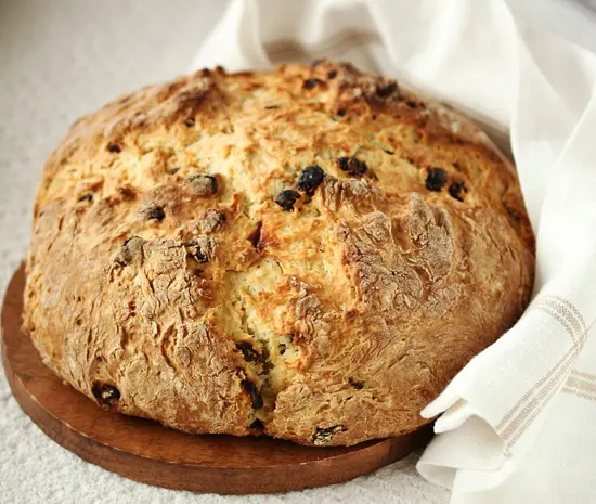 A loaf of bread with raisins on top.