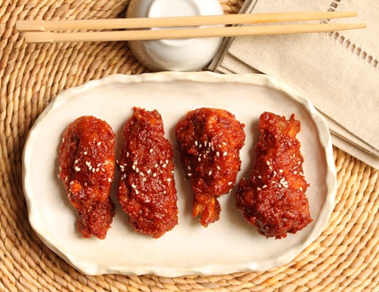 A plate of food with four pieces of chicken.