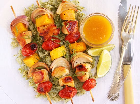 A plate of food with chicken kabobs and vegetables.