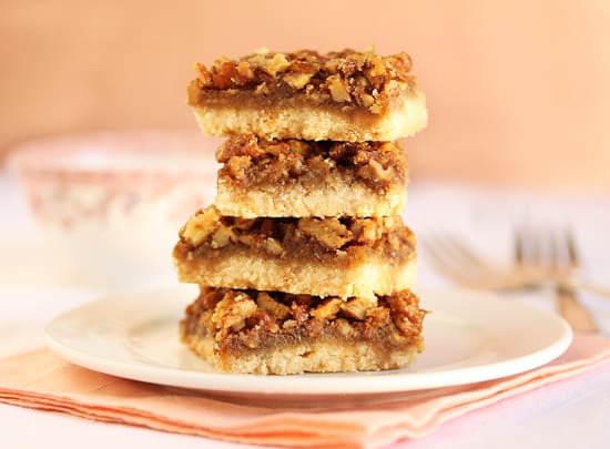 Three pieces of pecan pie bars stacked on top of each other.