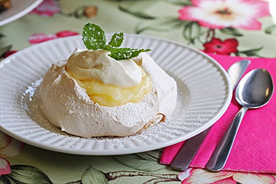A white plate topped with a lemon filled meringue.