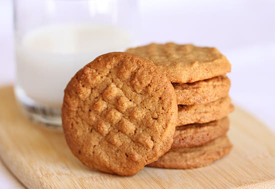 A stack of peanut butter cookies on top of a wooden table.