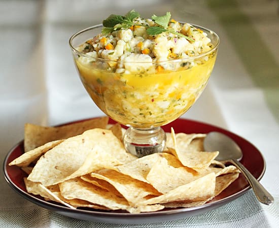 A bowl of corn salsa and tortilla chips on the table.