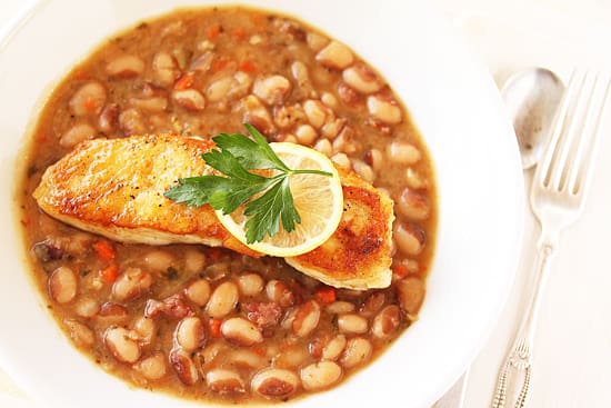A plate of food with beans and fish.