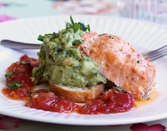 A plate of food with salmon and guacamole.