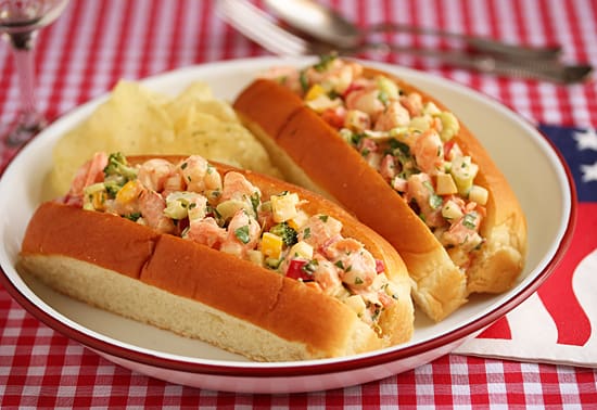 Two hot dogs on a plate with corn chips.