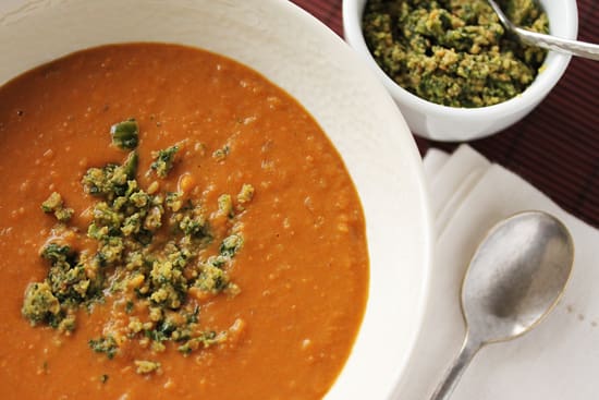 A bowl of soup and a cup of broccoli.