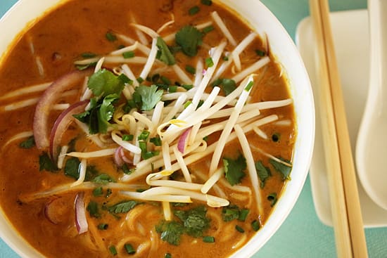A bowl of soup with cheese and cilantro.