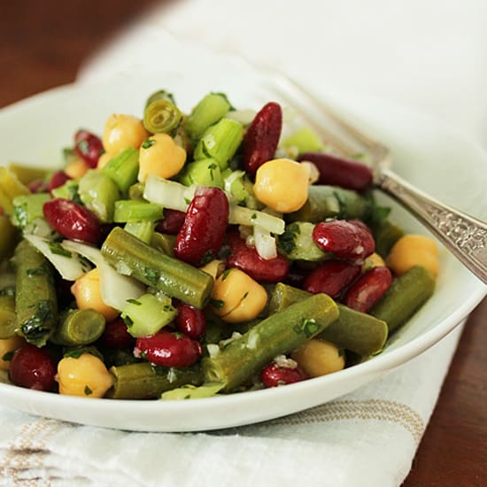 A bowl of beans and vegetables on top of a table.