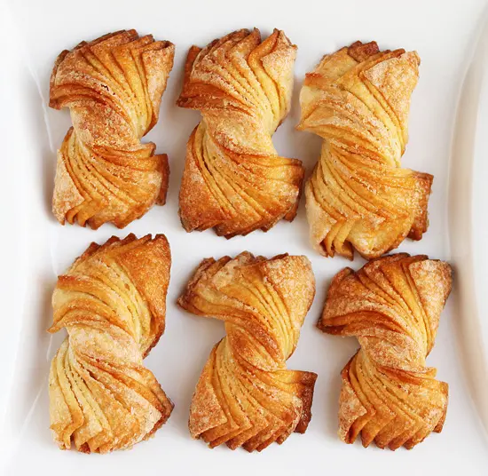 A white tray with six pastries on it.
