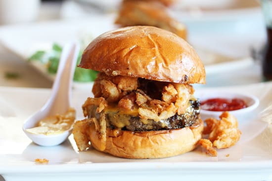 A hamburger with lots of meat and sauce on it.