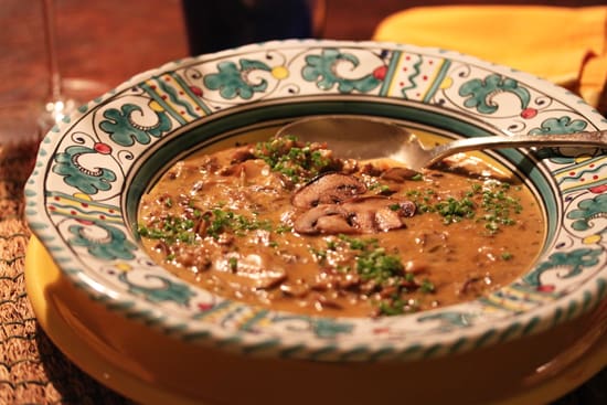 A bowl of soup with broccoli and meat.