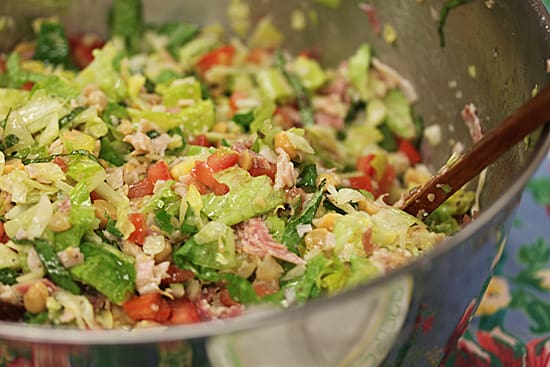 A bowl of salad with tomatoes, lettuce and other vegetables.