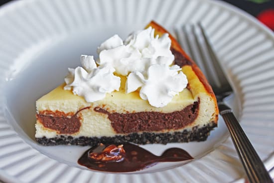 A piece of cheesecake with whipped cream on top.