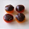 Four tomatoes with a dark brown crust on top.