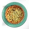 A green plate with a quiche on it