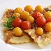 A plate of food with tomatoes on top.