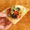 A person holding up a tortilla with some food on it