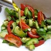 A salad with tomatoes, cucumber and green peppers.