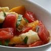 A bowl of food with tomatoes and cheese.