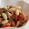 A bowl of beans and tomatoes on top of rice.