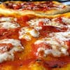 A close up of some pizza with cheese and sauce