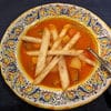 A bowl of soup with tortilla strips on top.