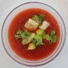 A bowl of soup with some vegetables on top