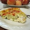 A slice of quiche on top of a white plate.