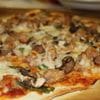 A pizza with mushrooms and sausage on it.