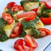 A plate of food with tomatoes and tofu.