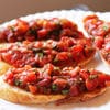 A plate of bruschetta with tomatoes and basil.
