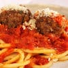 A plate of spaghetti and meatballs with tomato sauce.