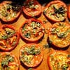 A bunch of tomatoes that are on the counter.